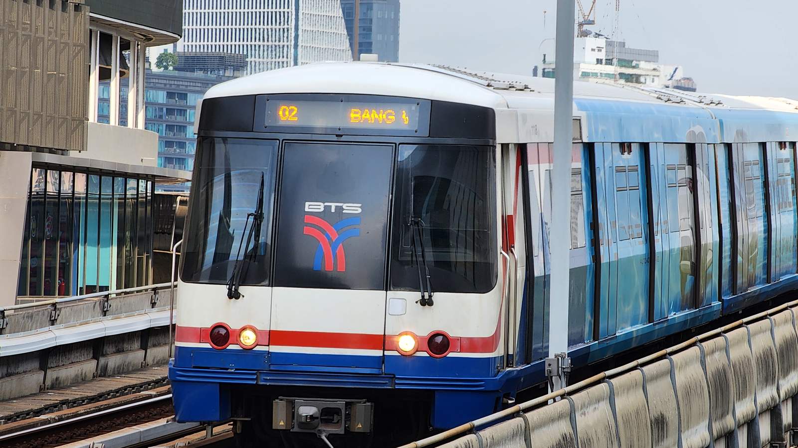 BTS 空鐵列車駛進 Sala Daeng 站，白底藍紅線條的車頭上方亮著目的地看板