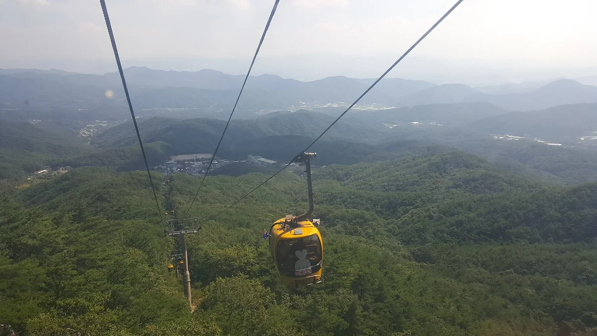 八公山纜車的黃色車廂在山谷上方運行,背後是連綿的綠色山稜