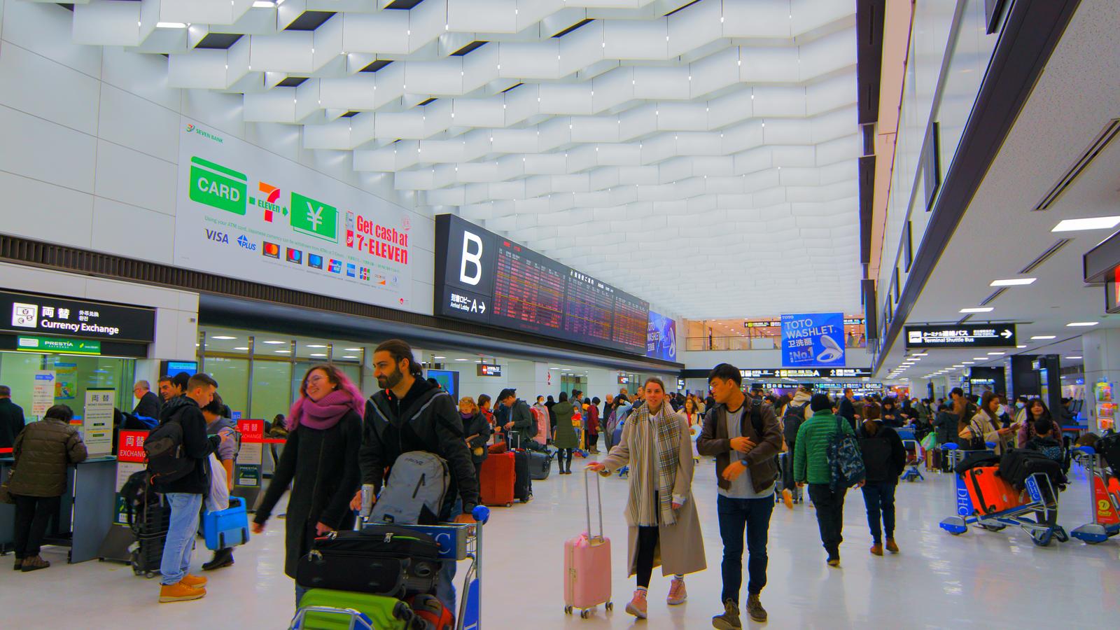 成田機場第 2 航廈入境大廳，挑高的室內空間與等候的旅客