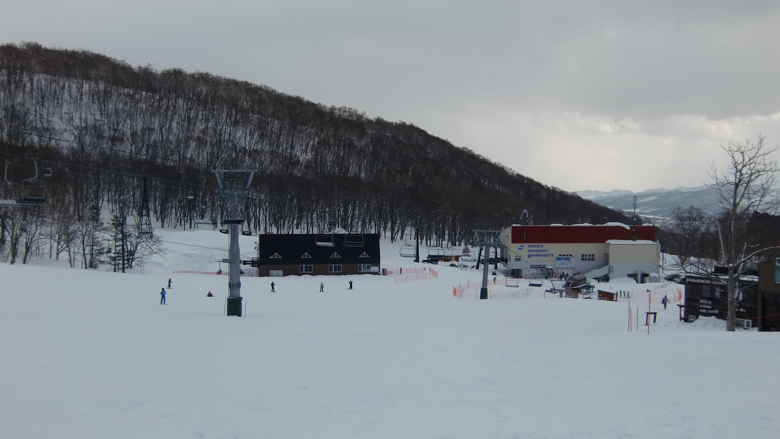 二世谷 Annupuri 國際滑雪場的纜車與兩條四人吊椅，雪道上有滑雪的人