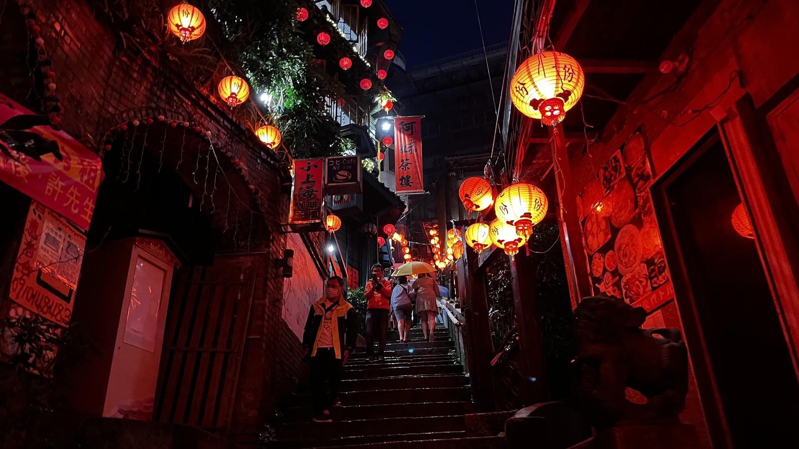 Jiufen Old Street at night with rows of red lanterns glowing along the stepped alley