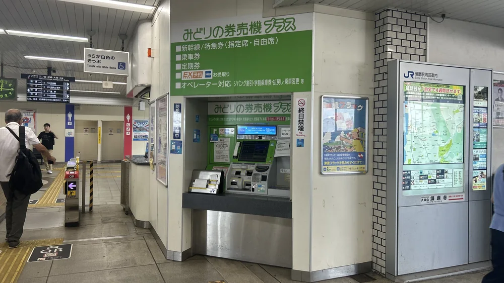 JR 西日本車站裡的綠色售票機みどりの券売機プラス，綠色機身，上方有可辦理票種的看板