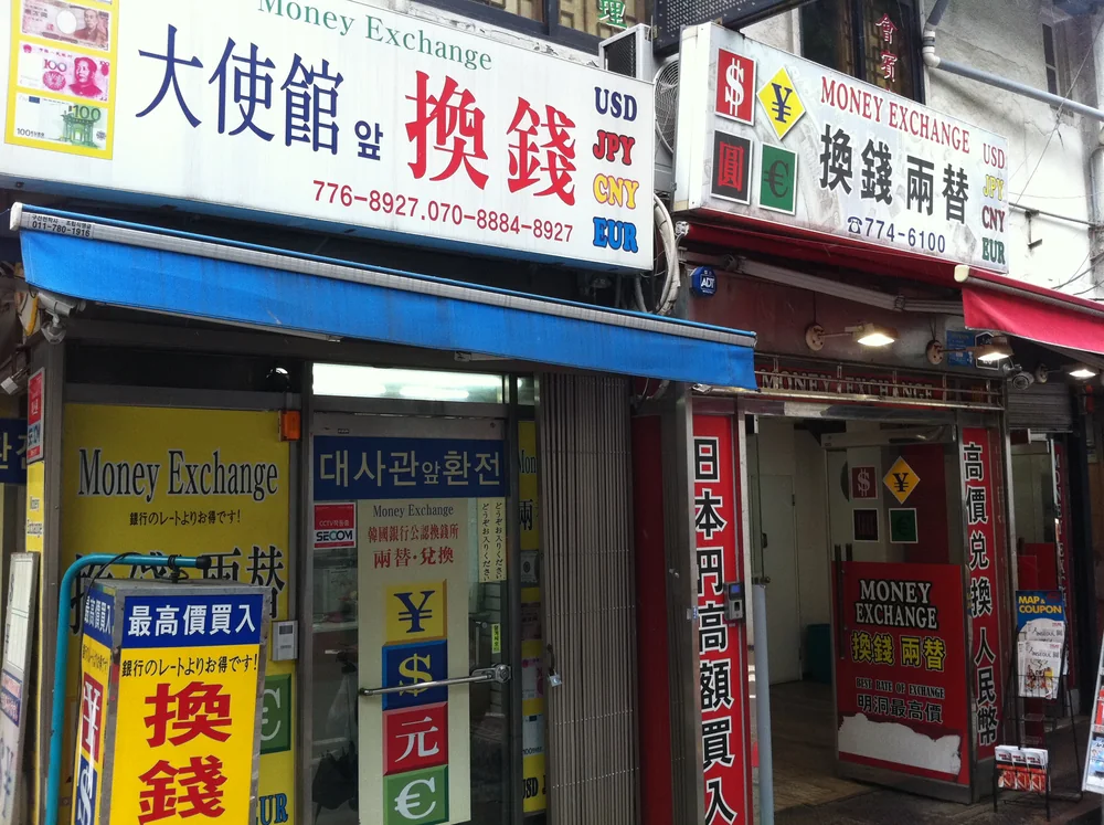 首爾明洞街上密集的店家招牌，其中包括換錢所的看板
