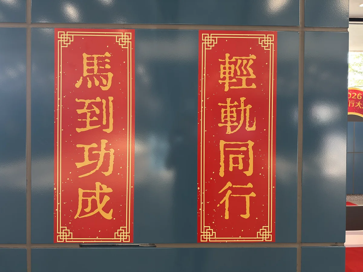 澳門輕軌媽閣站大堂牆上貼著兩幅金字紅底的農曆新年揮春