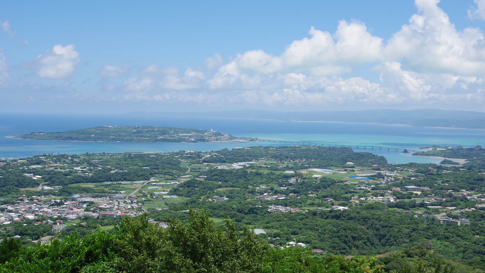 從乙羽岳展望台俯瞰古宇利大橋橫過翠綠淺海連到古宇利島