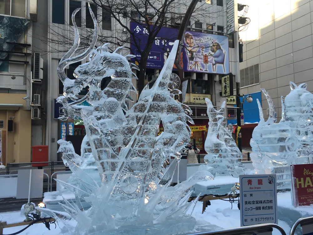 すすきの會場白天的透明冰雕青龍，背景是駅前通的商店招牌