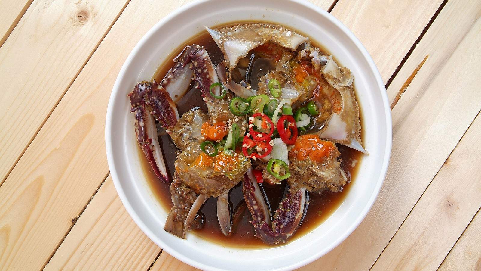 醬油醃蟹盛在盤中，蟹身與蟹殼可見