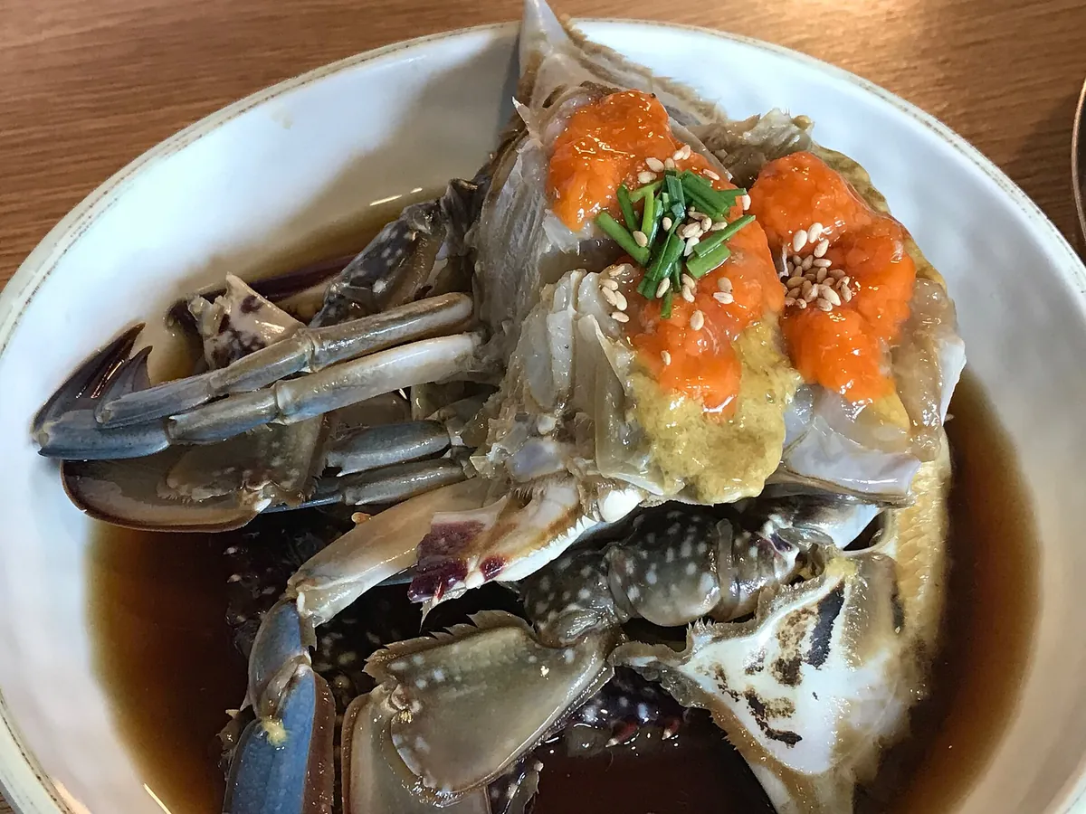 盤中的醬油醃蟹特寫，蟹身與蟹殼可見