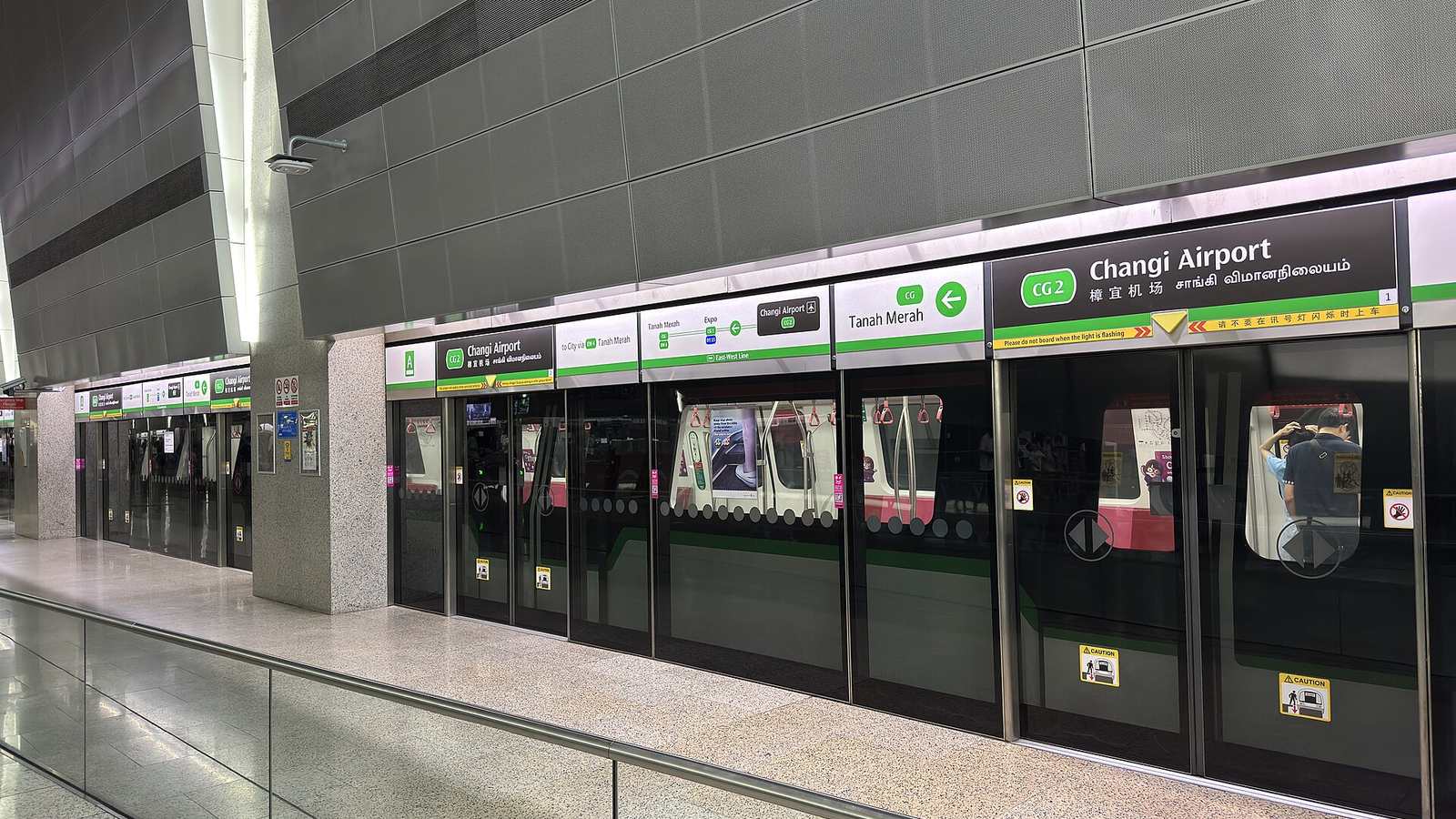Platform at Changi Airport MRT station (CG2), with a sign above the platform doors pointing towards Tanah Merah