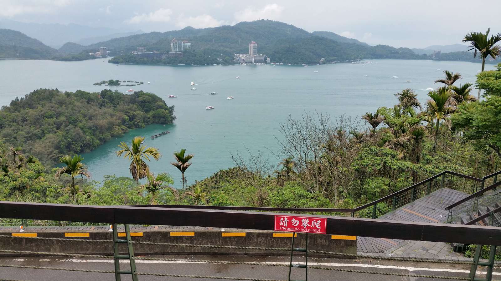 Sun Moon Lake seen from the shore, with Lalu Island and green mountains under a clear sky