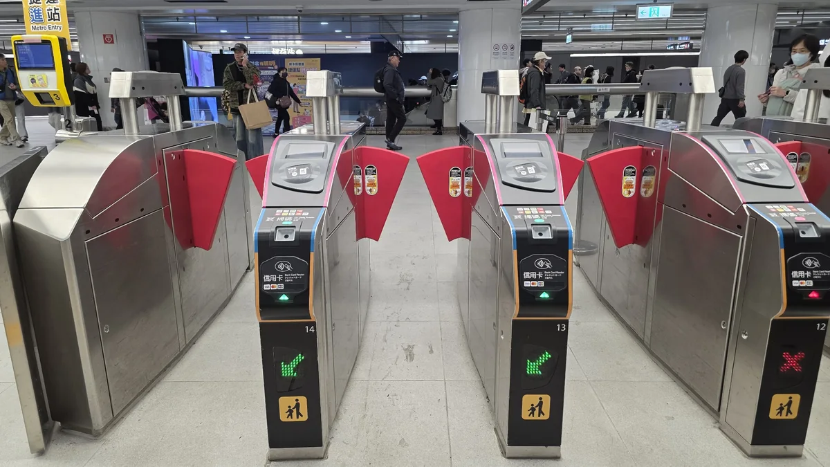 Taipei Metro fare gates with a separate panel marked 信用卡 Bank Card Reader showing Visa, Mastercard and JCB logos, below a QR code scanner