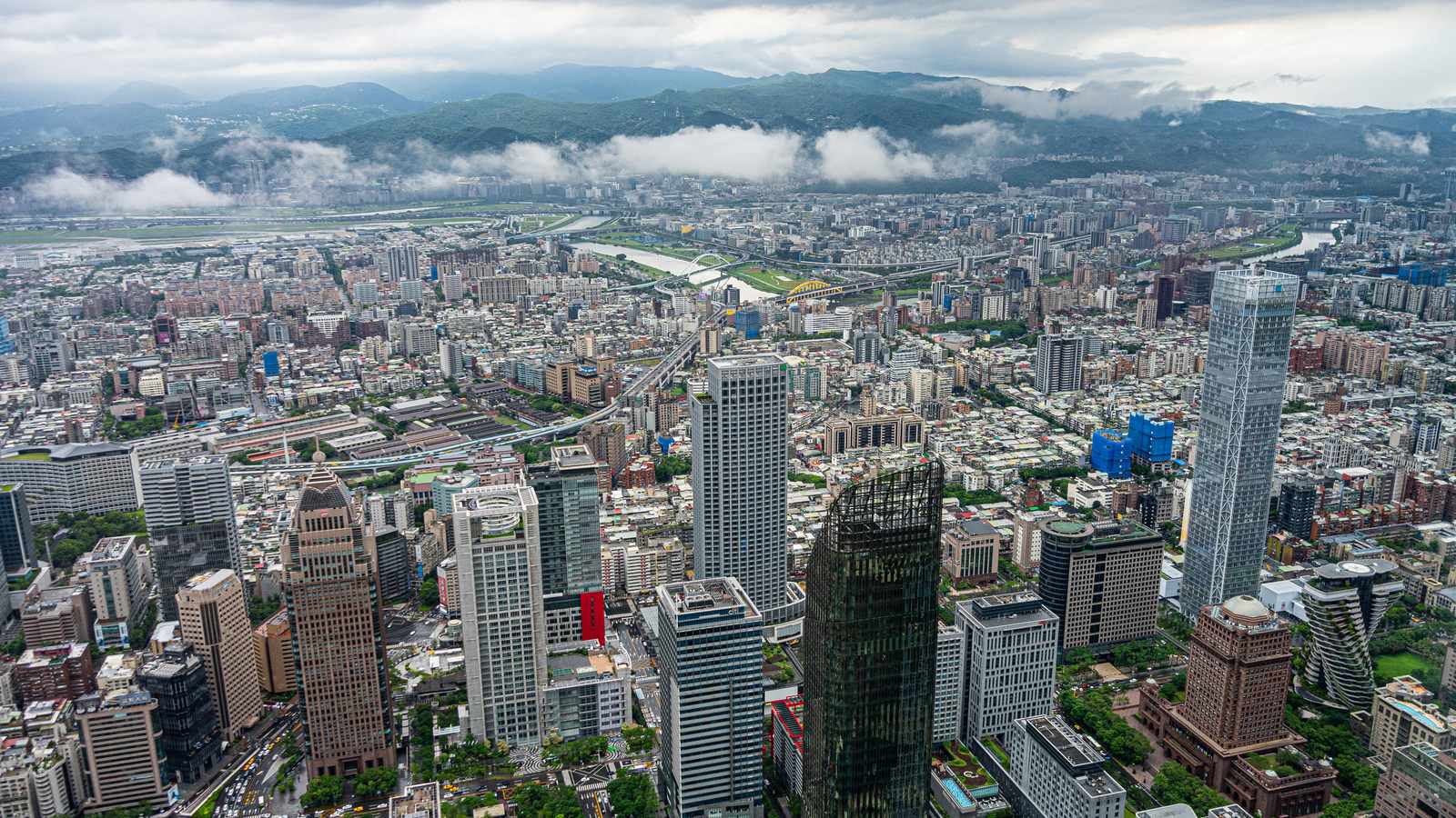 Taipei's high-rises, river and green hills under low cloud, seen from the Taipei 101 observatory