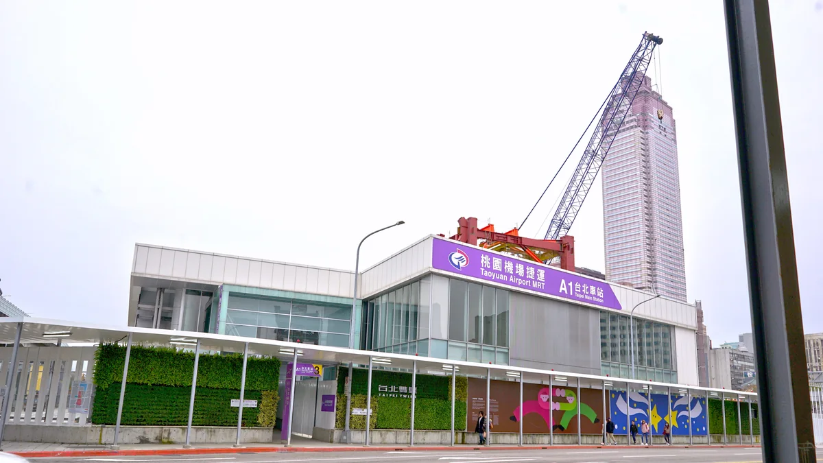 Exit 3 of the Airport MRT's A1 Taipei Main Station, with its purple sign and Shin Kong Life Tower behind