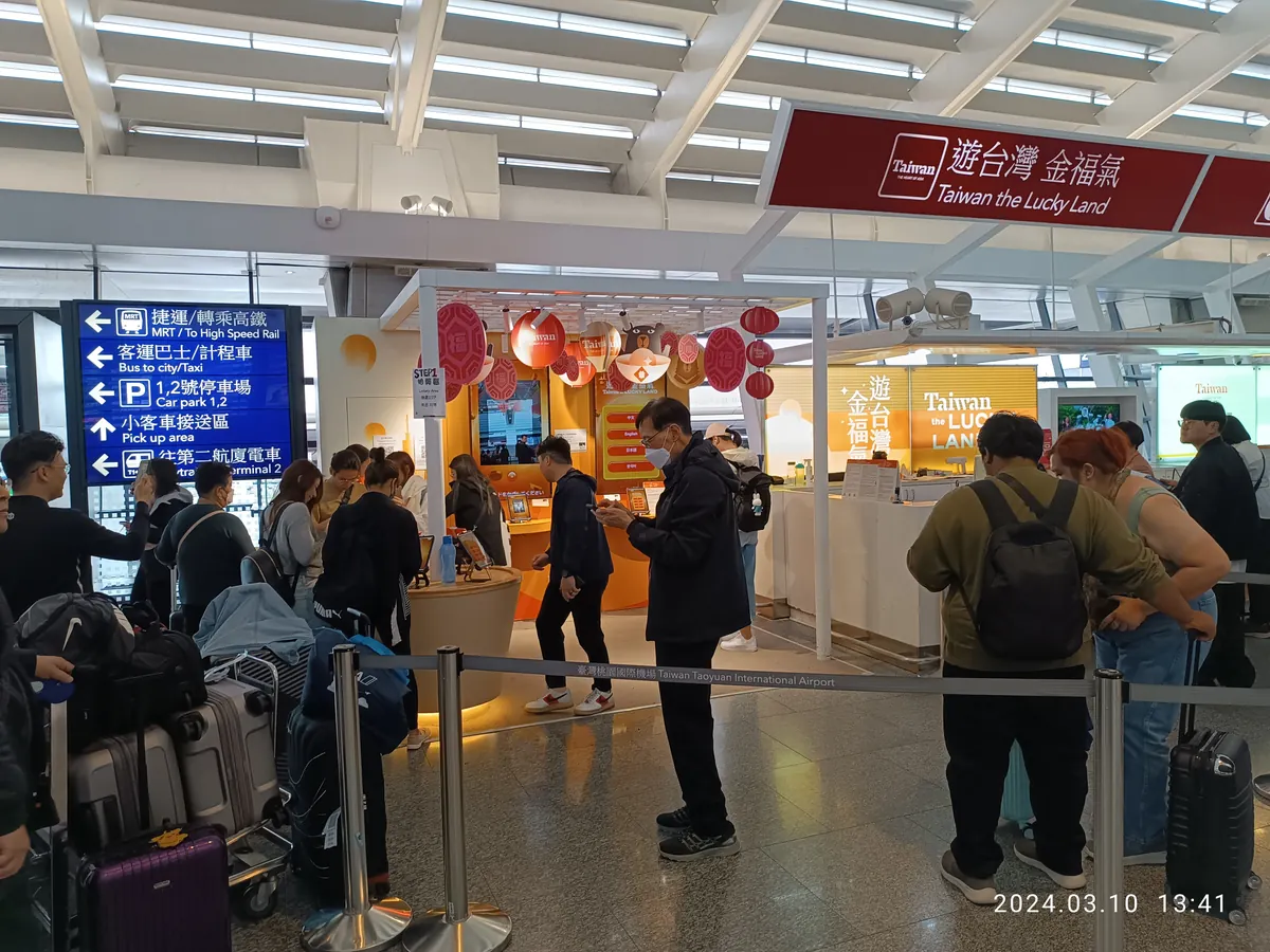 Taoyuan Airport Terminal 1 arrival hall with signs to the MRT, buses, taxis and the Skytrain to Terminal 2