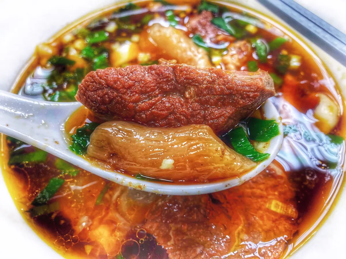 대만식 紅燒牛肉麵 클로즈업. 숟가락으로 소고기와 힘줄을 들어 올린 모습
