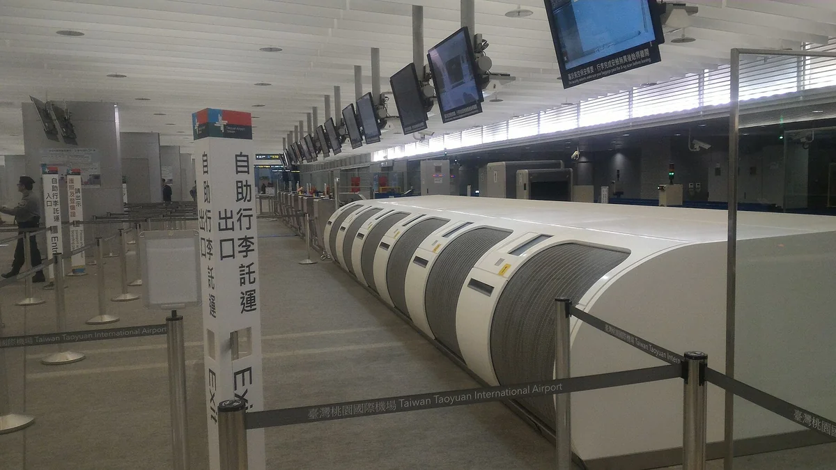 The self-service bag-drop area at Airport MRT A1 Taipei Main Station, with a self-service bag-drop exit sign and a baggage X-ray machine behind it