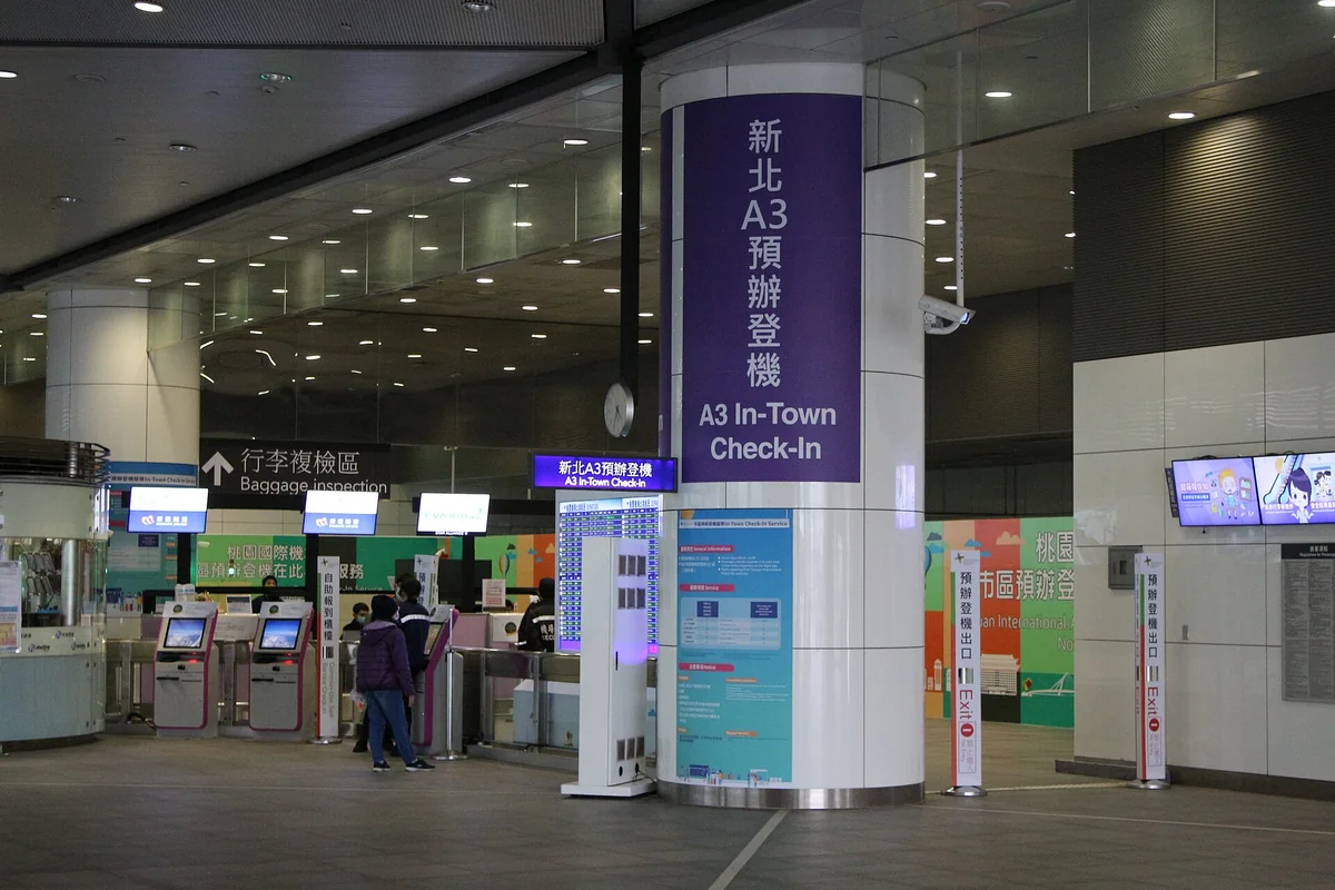 The A3 In-Town Check-In area at New Taipei Industrial Park Station, with an A3 In-Town Check-In sign on a pillar and self-service kiosks beside it